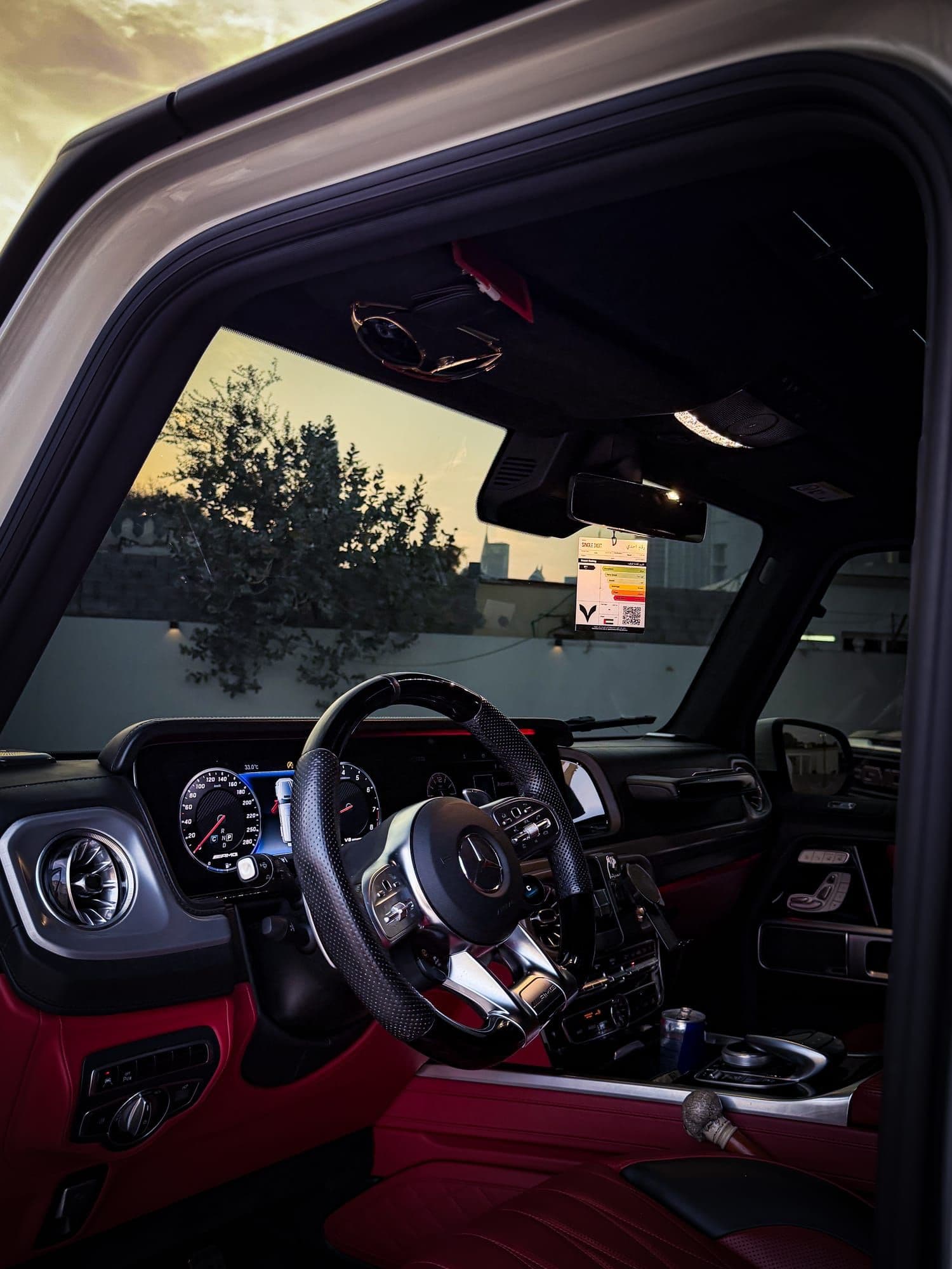 Night Drive air freshener hanging from the rear-view mirror, red leather cabin at sunset