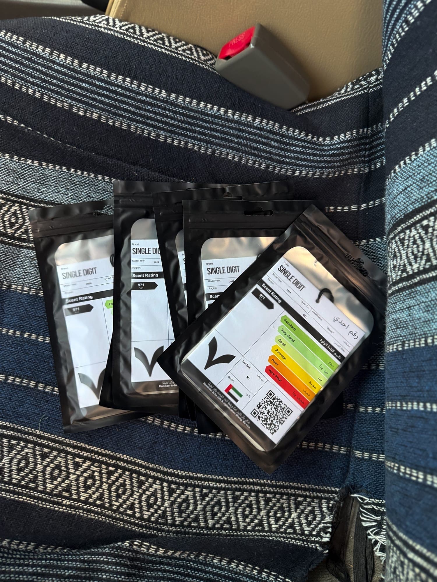 Night Drive air fresheners in their black packs on a woven car seat